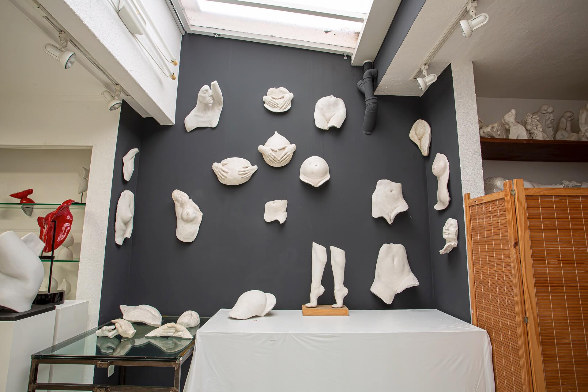 Parede do ateliê com moldagens em gesso de partes do corpo humano